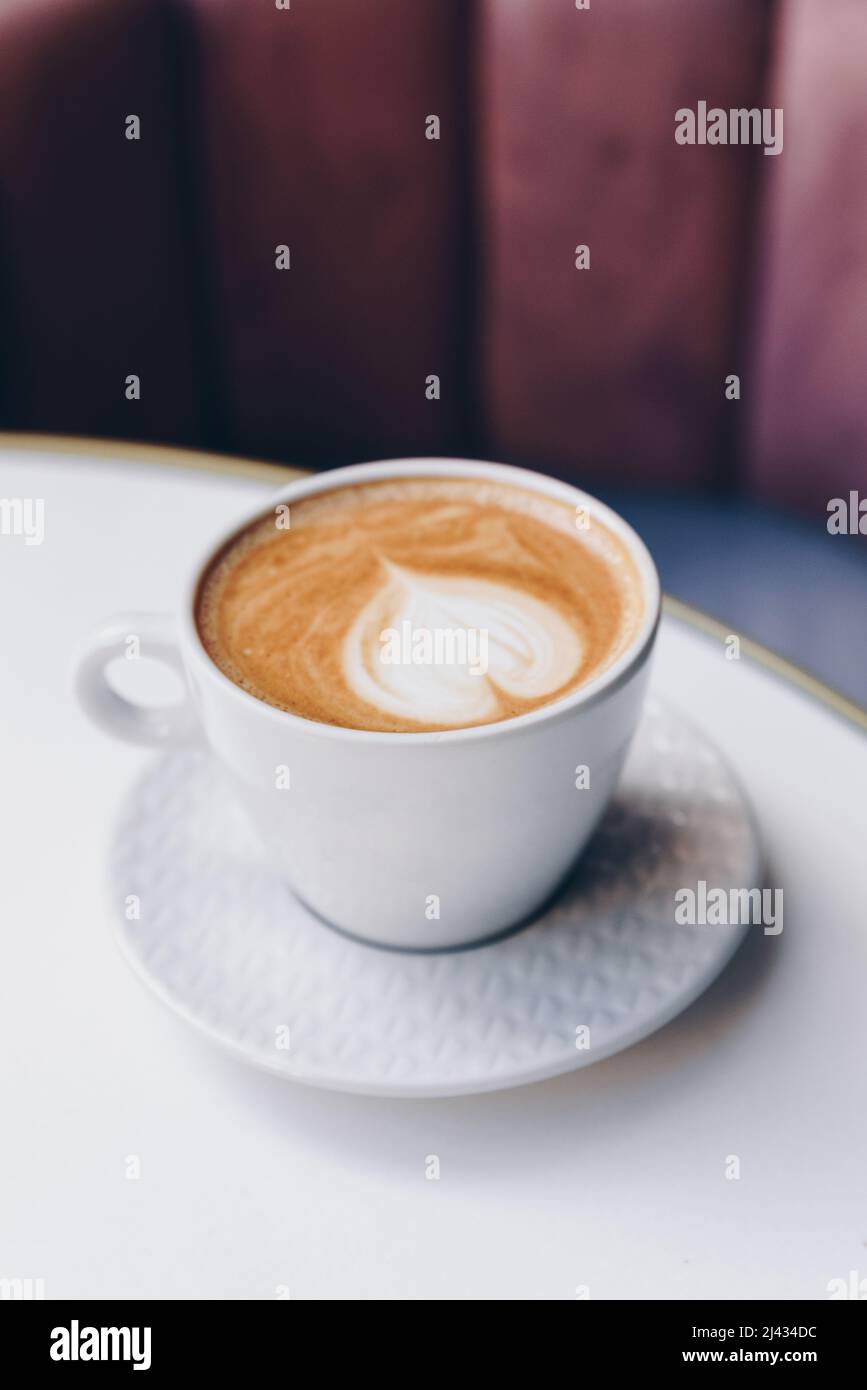 Une tasse de cappuccino chaud sur une table en marbre dans le café. Banque D'Images