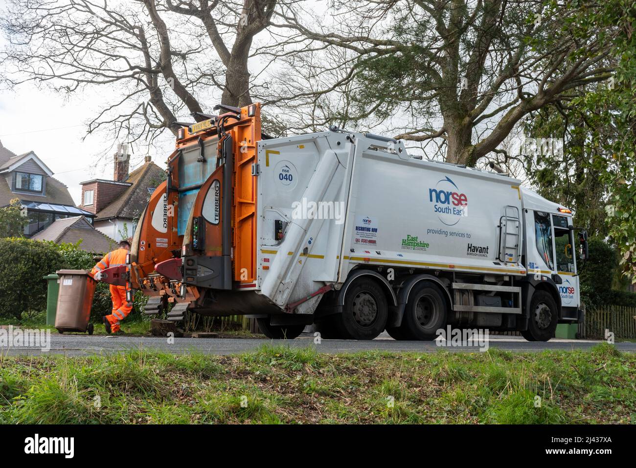Norse camion-poubelle du Sud-est, fournissant des services d'élimination des déchets à East Hampshire, Angleterre, Royaume-Uni, avec un binman vidant les poubelles domestiques Banque D'Images