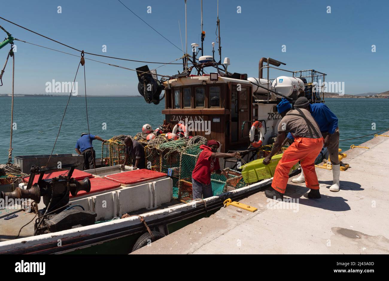 Baie de Saldanha, côte ouest, Afrique du Sud. 2022. Bateau de pêche à côté à Saldanha avec l'équipage déchargeant les prises de homards. Banque D'Images