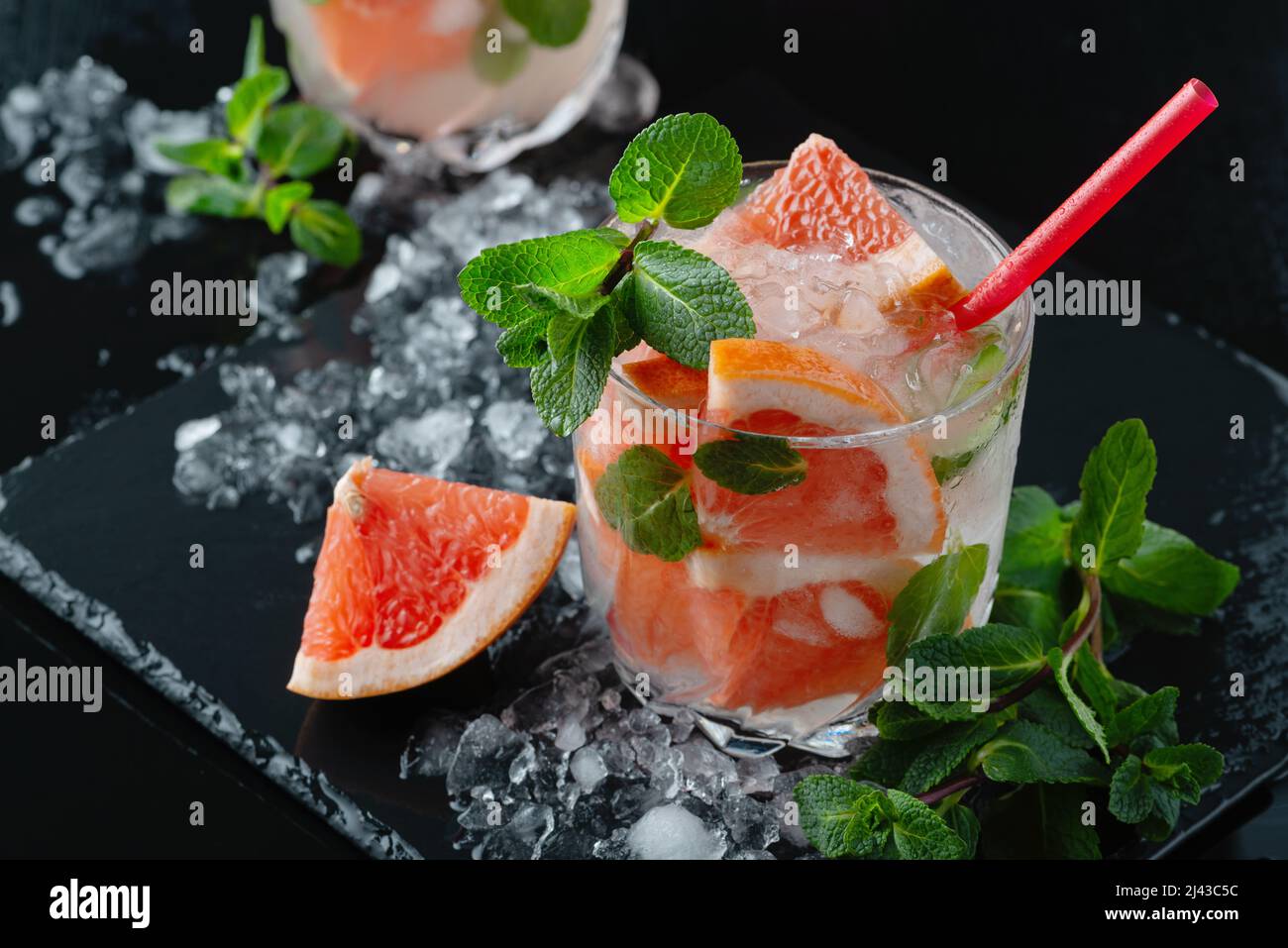 Cocktail de pamplemousse rafraîchissant avec glace et menthe sur fond noir Banque D'Images