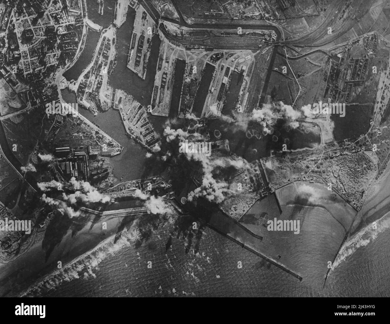 Attaque contre Dunkird par l'U.S.A.A.F. Des bombes éclatant sur le look Trystian peuvent être vues ainsi que des coups sur l'extrémité intérieure de la jetée est et salvo d'au moins 15 éclats à travers le canal d'approche et le quai à l'ouest. Cette photo a été prise par des caméras automatiques dans les 8th bombardiers de l'armée de l'air. Une photo prise lors d'une attaque contre Dunkird le 15,2.43. Par avion libérateur de l'U.S.A.A.F. Escortés par les combattants toutes les bombes à travers la partie nord du port. 25 février 1943. (Photo b Banque D'Images