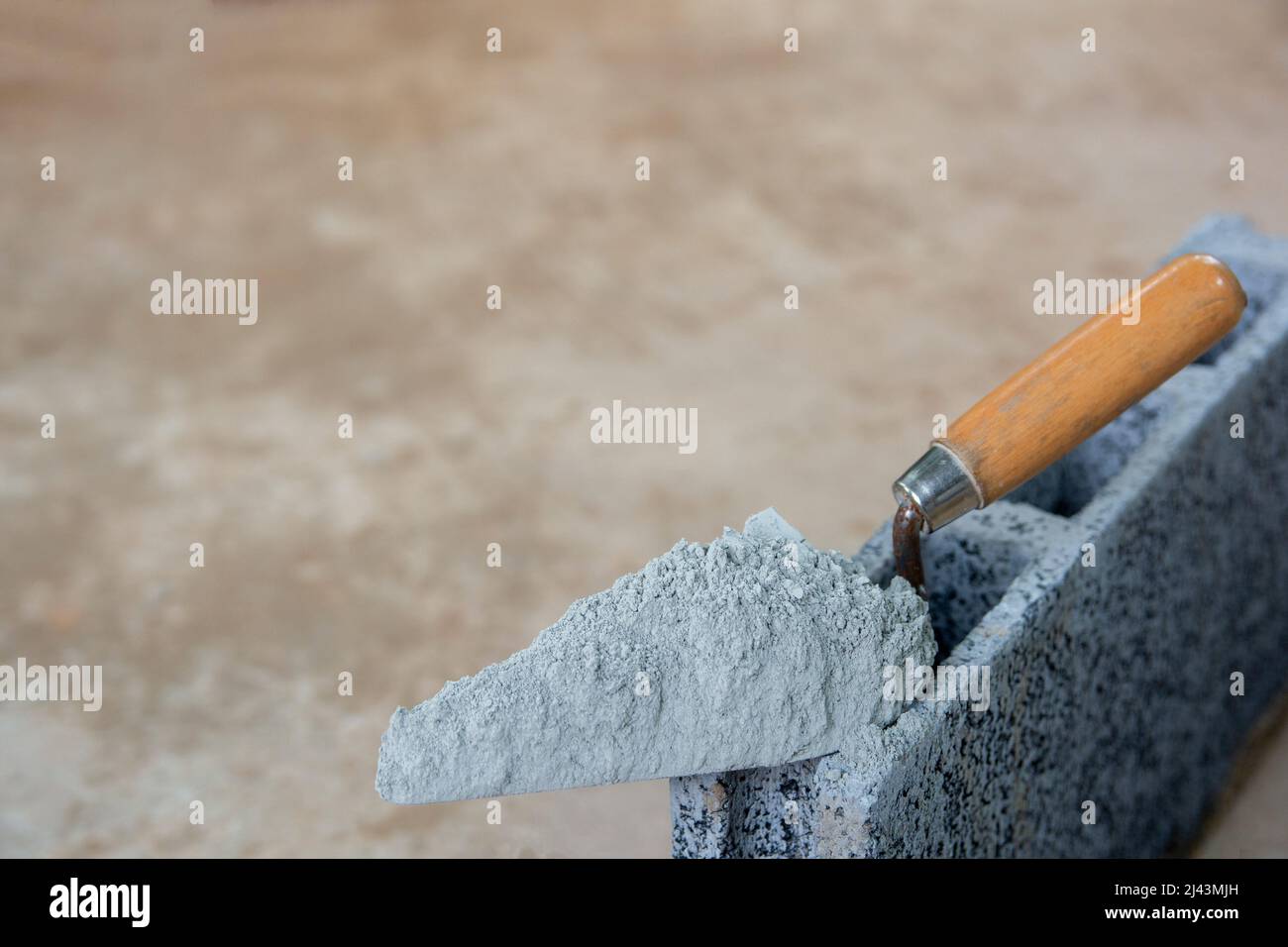 Poudre de ciment ou mortier avec truelle mis sur la brique de béton pour  les travaux de construction Photo Stock - Alamy