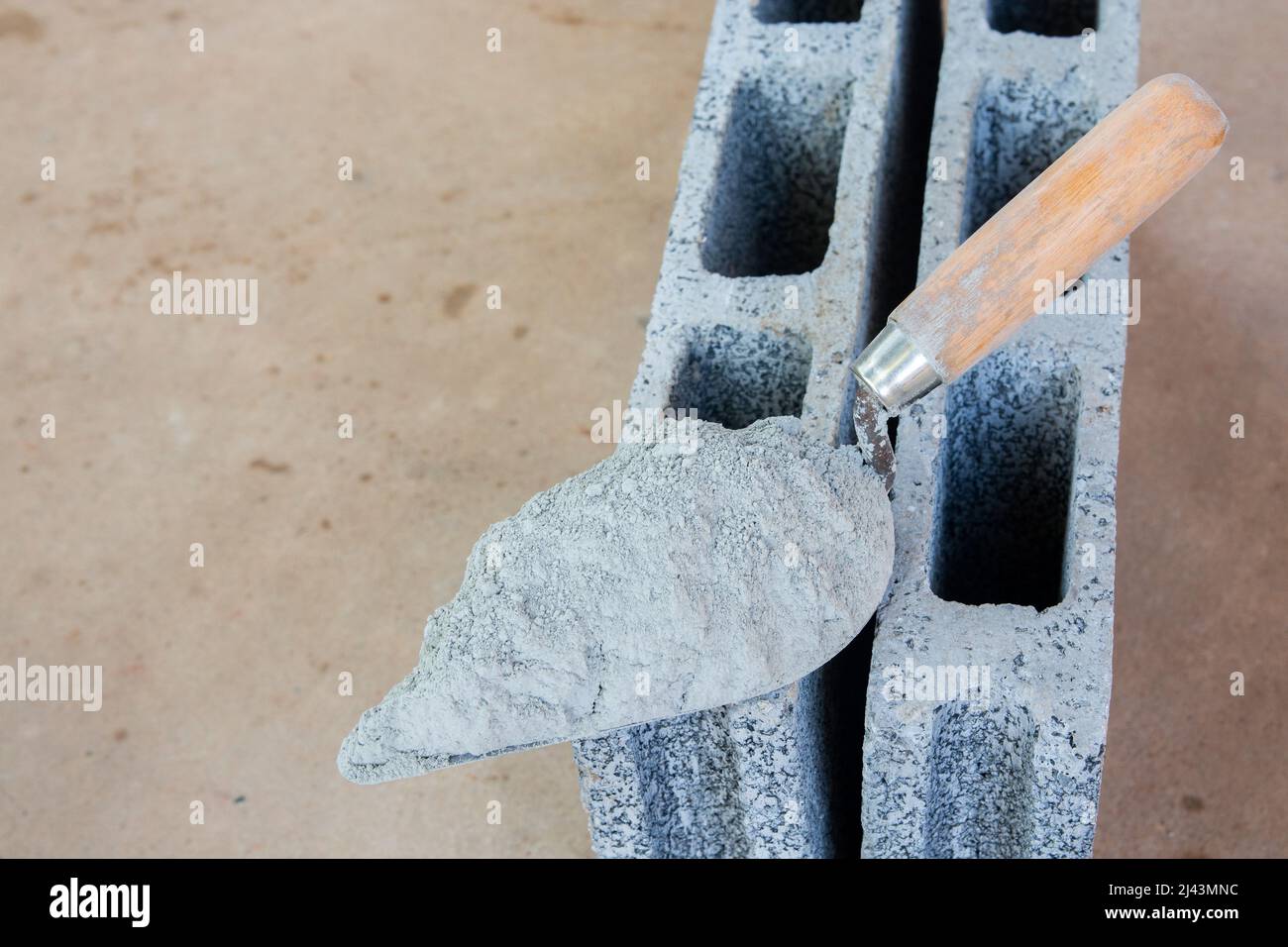 Poudre de ciment ou mortier avec truelle mis sur la brique de béton pour  les travaux de construction Photo Stock - Alamy