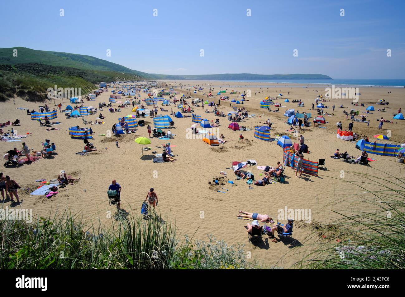 Les gens profitent du soleil sur une plage de sable de la station balnéaire de Woolacombe, sur la côte nord du Devon, en Angleterre Banque D'Images