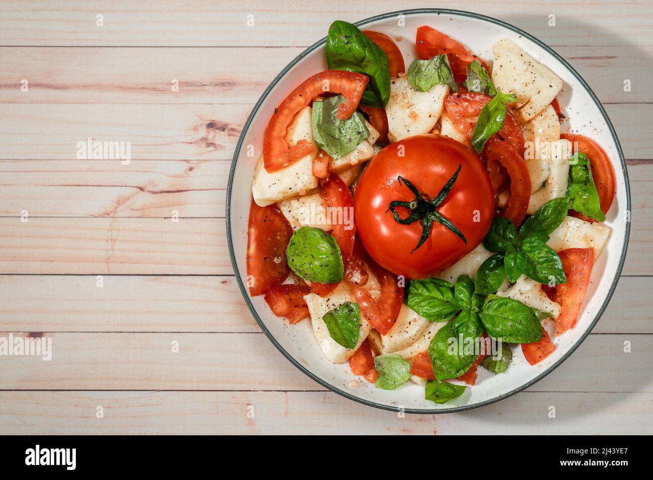 Salade italienne classique de mozzarella, tomate et basilic avec huile d'olive et vinaigre. Vue de dessus et espace de copie. Banque D'Images