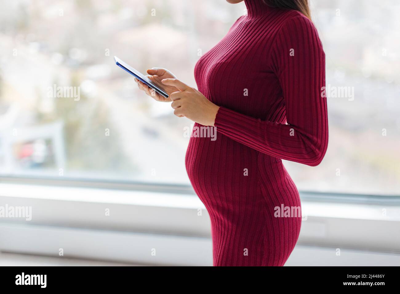 Femme enceinte utilisant un smartphone pendant la grossesse pour acheter  des vêtements de maternité, en utilisant l'application grossesse, faire un  bilan de santé rendez-vous des médecins Photo Stock - Alamy
