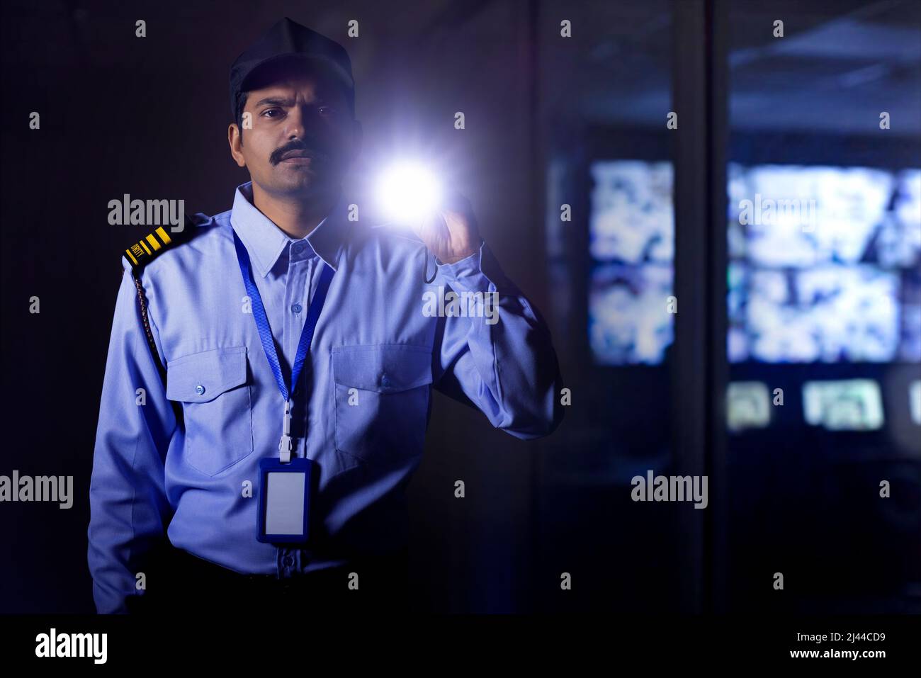 Garde de sécurité cherchant avec la lampe torche pendant le travail de nuit Banque D'Images