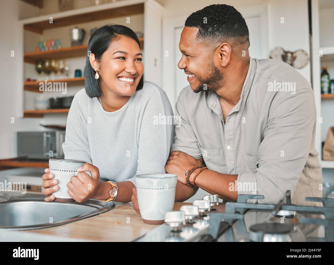 Chatte sur un joli petit placard. Photo d'un jeune couple qui boit du café ensemble dans la cuisine à la maison. Banque D'Images