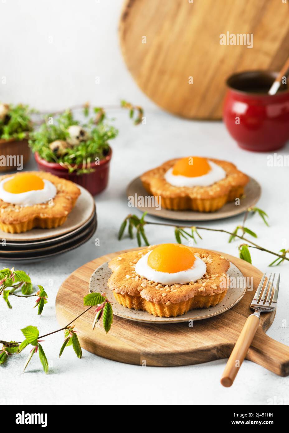 Gâteaux frais en forme de fleur sucrée avec abricot, glaçage et noix d'amande hachées. Banque D'Images