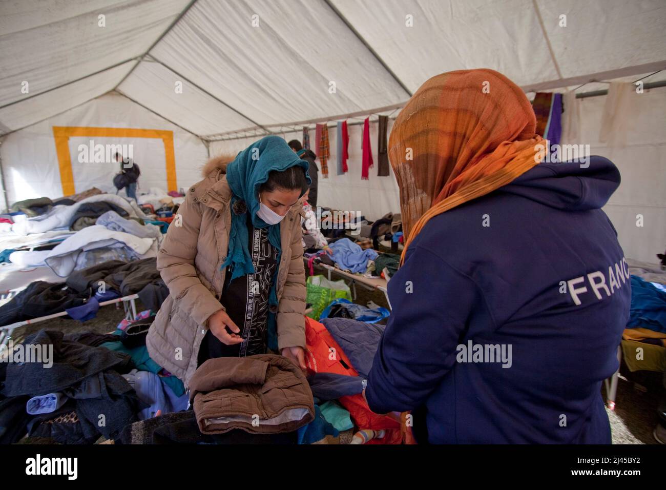 Briançon (Alpes françaises, sud-est de la France), 5 novembre 2021: Deux femmes à la recherche de vêtements pour leurs enfants dans une pile de vêtements donnés par l'habitude Banque D'Images