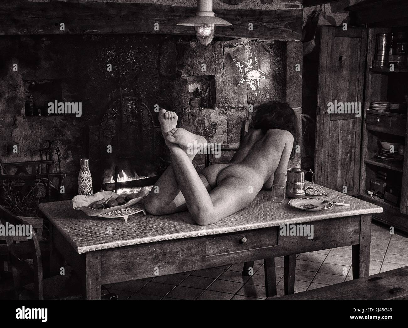 Femme nue allongé sur une table dans une vieille ferme Banque D'Images