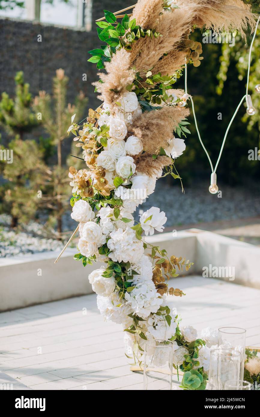 L'arche ronde est décorée de fleurs et de fleurs séchées. Détails de la cérémonie de mariage Banque D'Images