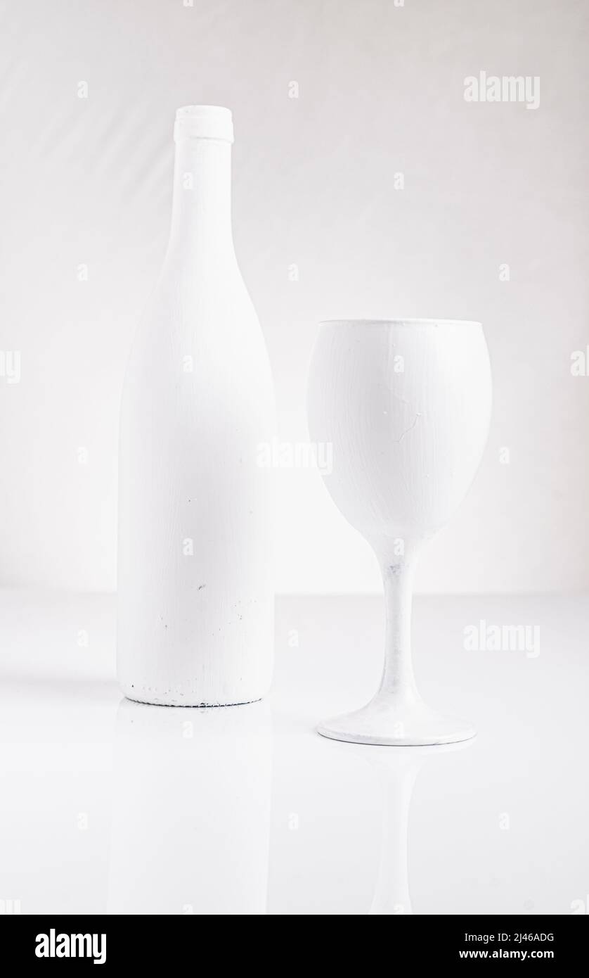 bouteille peinte en blanc et verre à vin dans un cadre très haut. Banque D'Images
