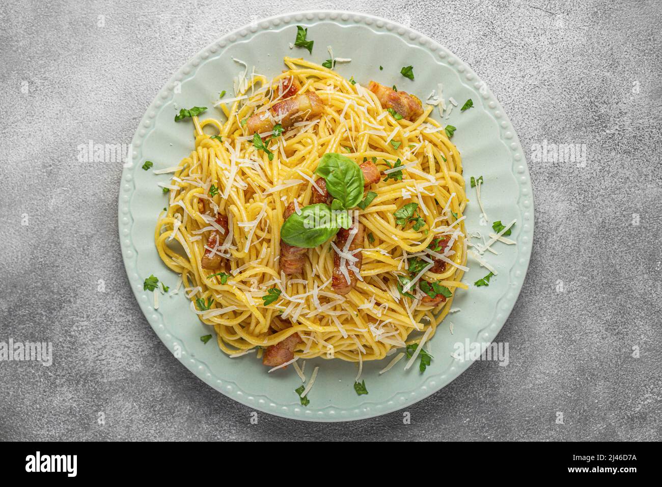 Spaghetti carbonara aux pâtes avec pancetta, bacon, œufs, parmesan et sauce crème sur table grise. Cuisine italienne. Vue de dessus Banque D'Images