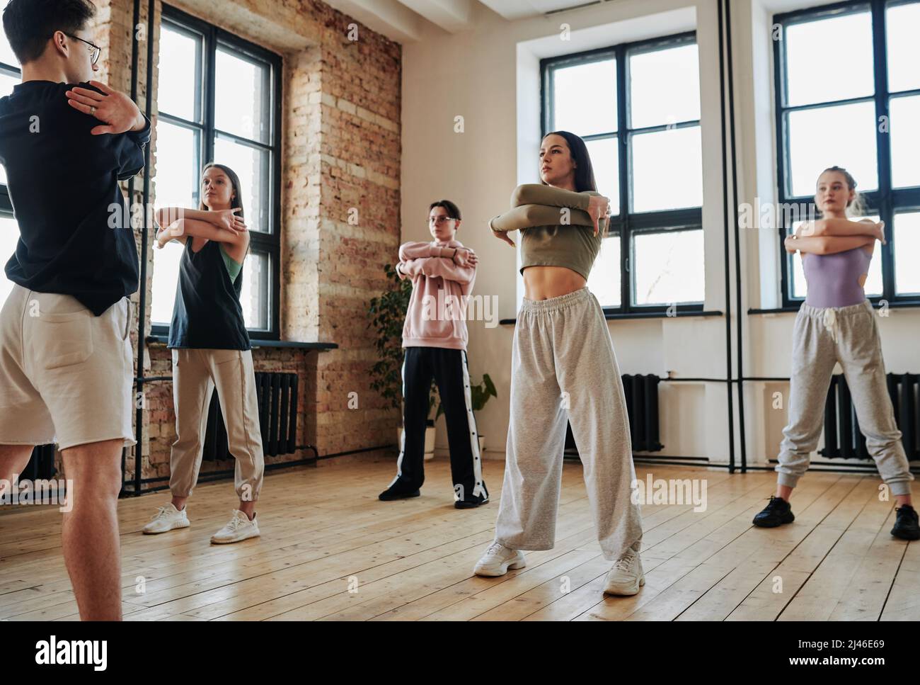 Adolescents contemporains en vêtements d'activité devant l'instructeur pendant l'entraînement ou la répétition d'un spectacle de danse vogue Banque D'Images