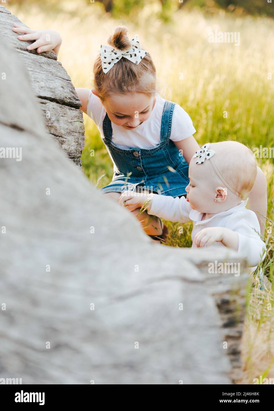 bébé et sœur jouant ensemble dans l'herbe Banque D'Images