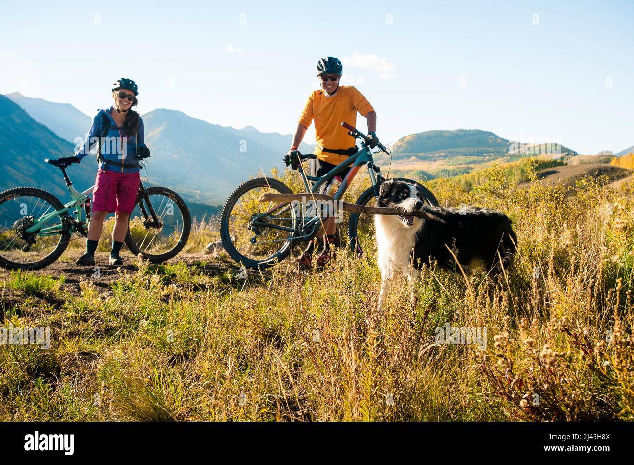 Un couple qui profite d'une balade en VTT à l'automne avec son chien Banque D'Images