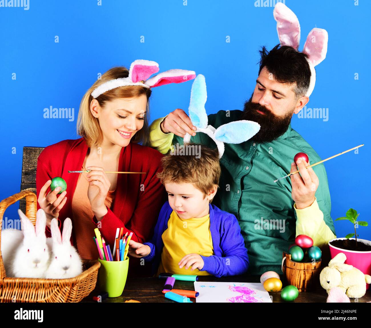 Famille de lapins dans les oreilles de lapin peinture des oeufs pour les vacances. Idées de décoration d'oeuf de Pâques. Banque D'Images