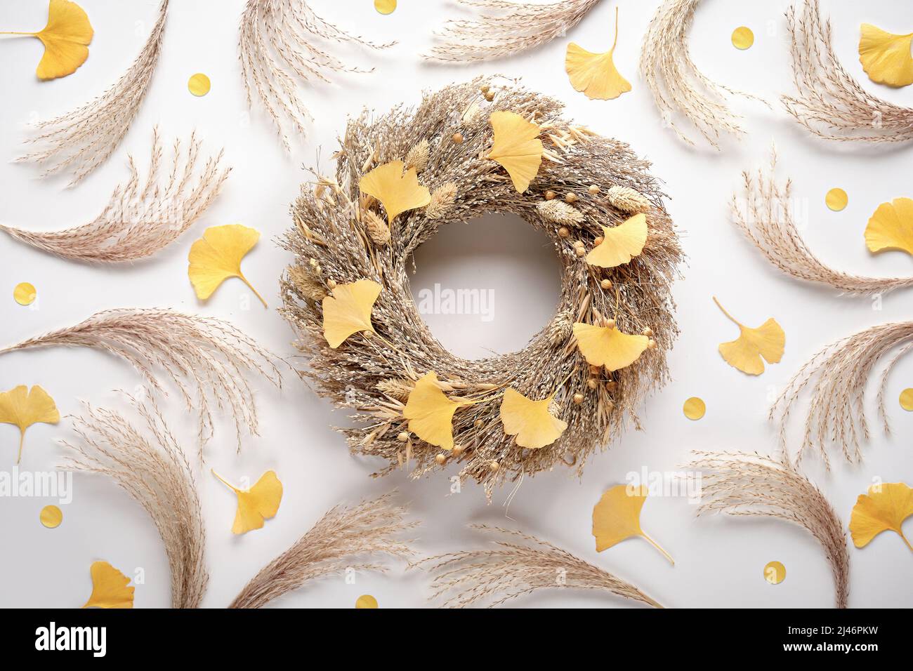 Arrière-plan de l'automne. Couronne d'herbe sèche. De fond blanc plat avec des feuilles de ginko et de l'herbe de pampas. Banque D'Images