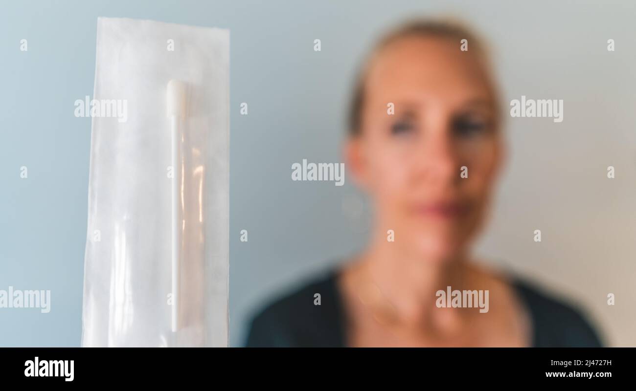 La femme maintient le écouvillon de test nasal PCR sras Covid 19 non ouvert sur la caméra Banque D'Images