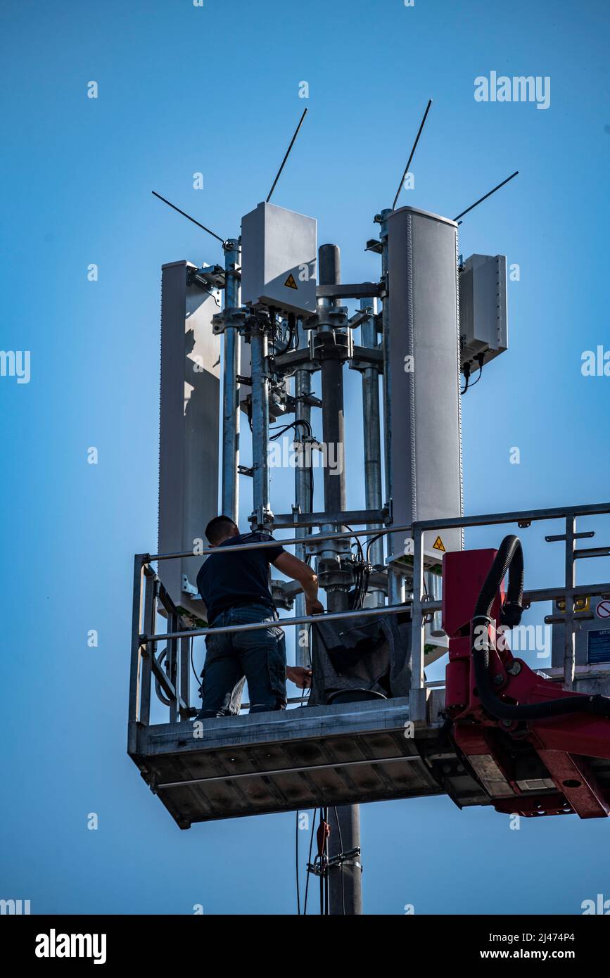Montage, installation d'un émetteur radio mobile 5G, mât dans un bâtiment résidentiel, Internet mobile rapide, Düsseldorf, NRW, Allemagne Banque D'Images
