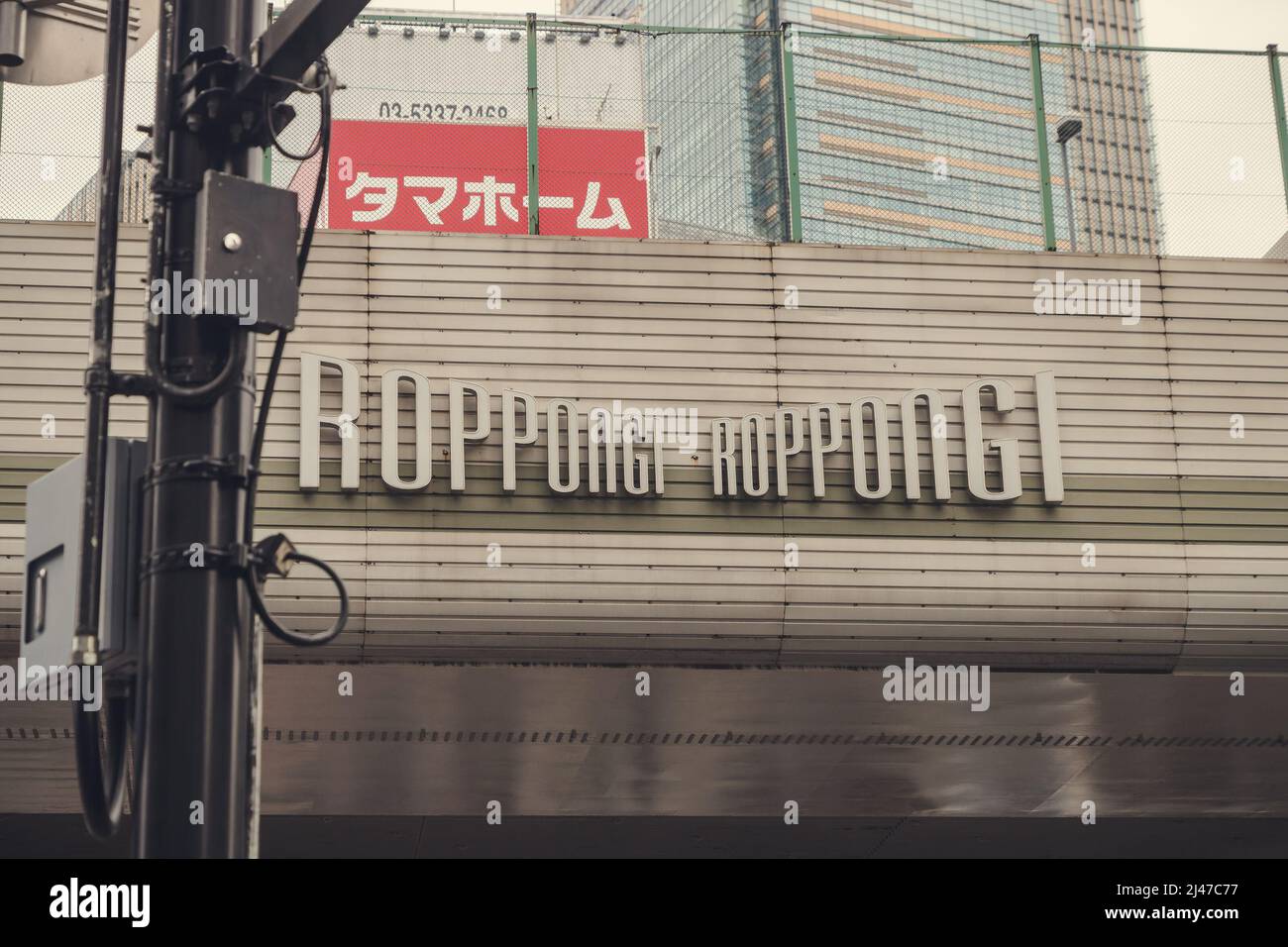 Grand panneau Roppongi sur un pont en face des gratte-ciel Banque D'Images