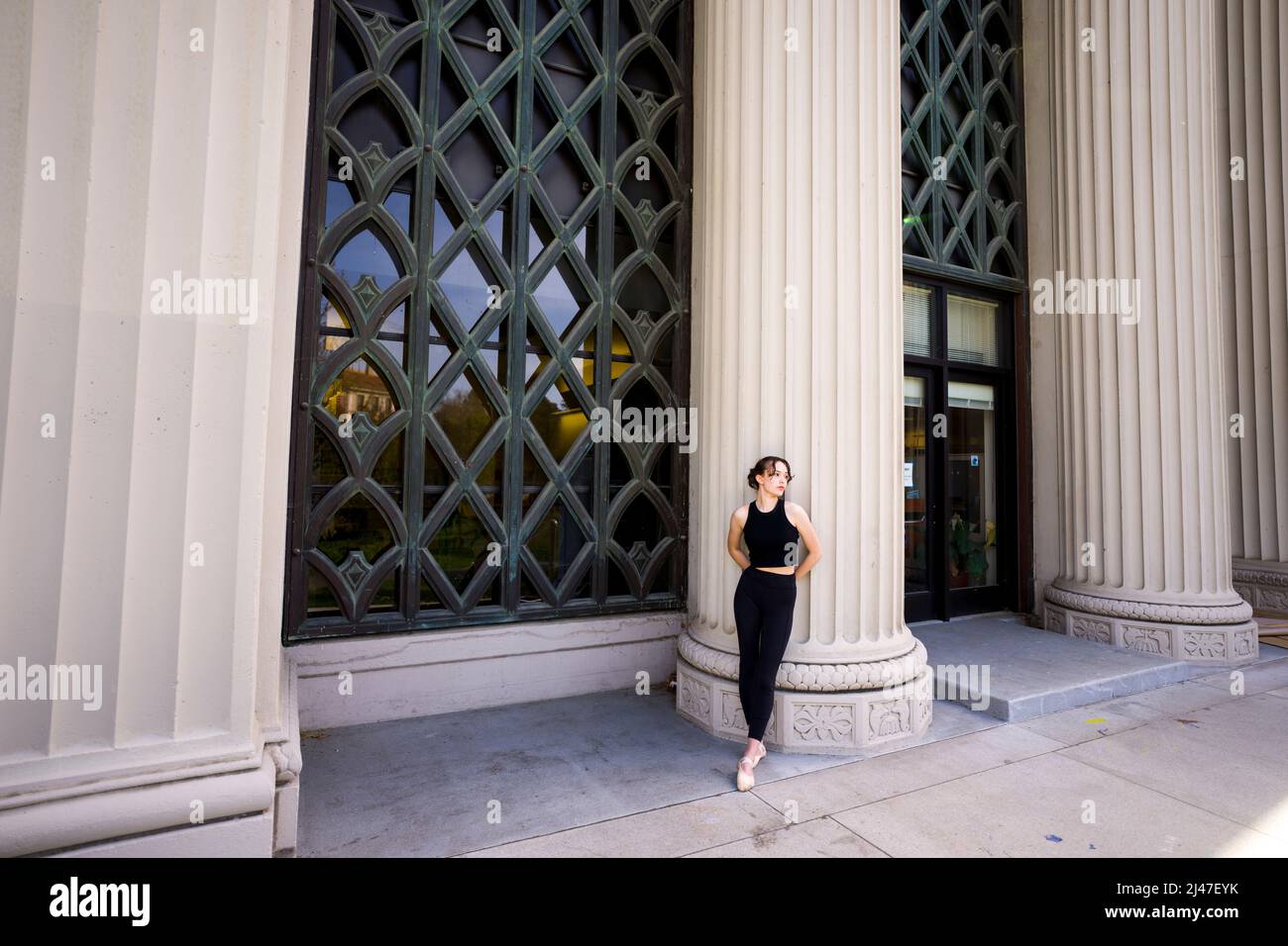 Une danseuse adolescente s'étirant sur les escaliers du bâtiment de psychologie de Berkeley Banque D'Images