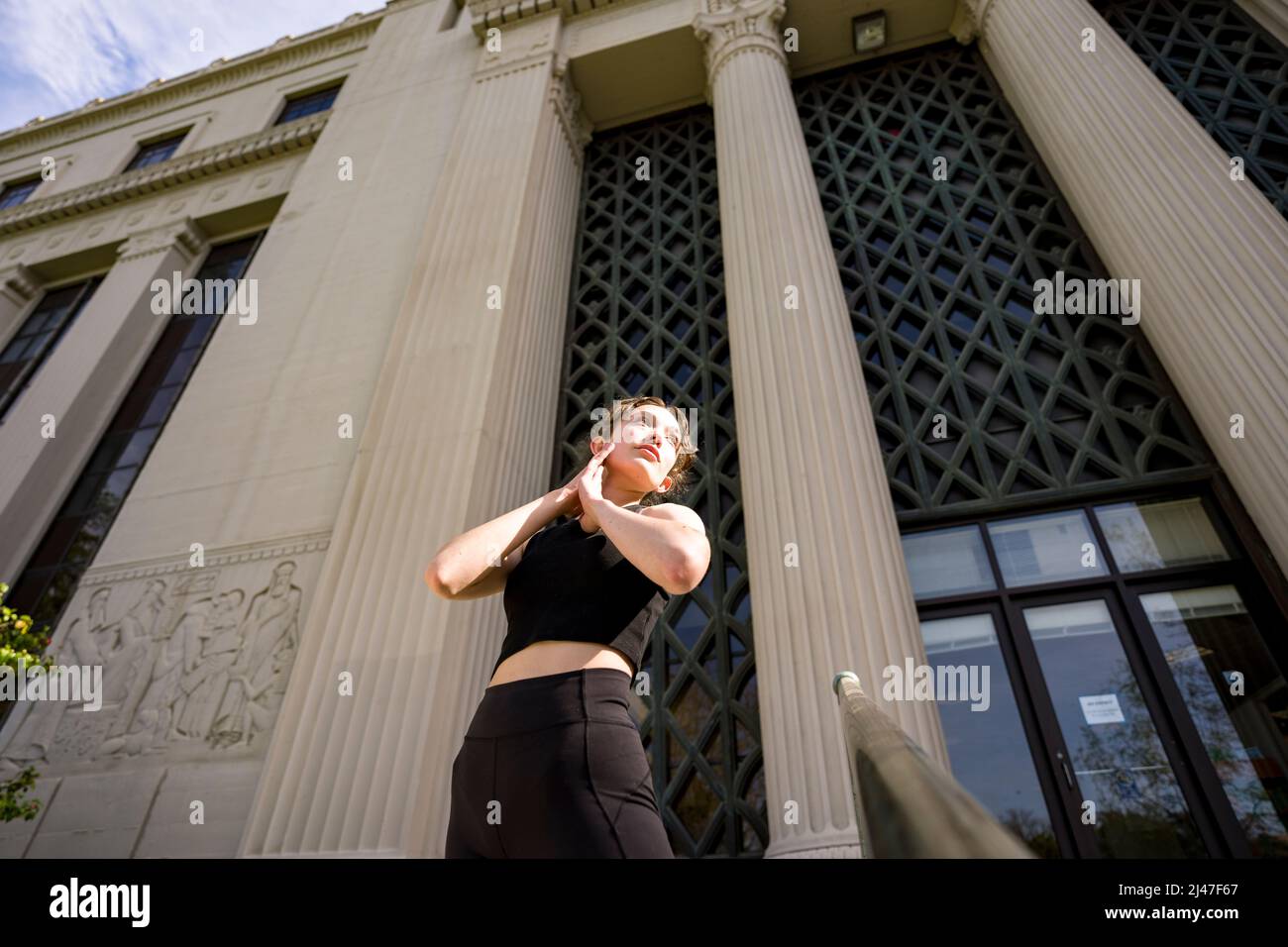 Une danseuse adolescente s'étirant sur les escaliers du bâtiment de psychologie de Berkeley Banque D'Images