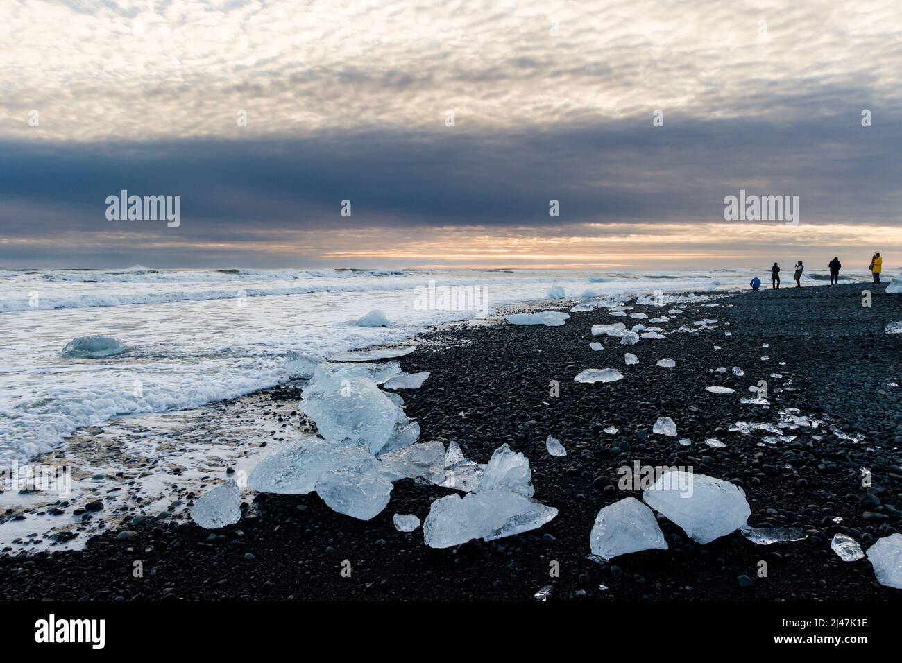 Morceaux de glace et icebergs cassés sur une plage de sable noir volcanique au crépuscule (Diamond Beach, Islande) Banque D'Images
