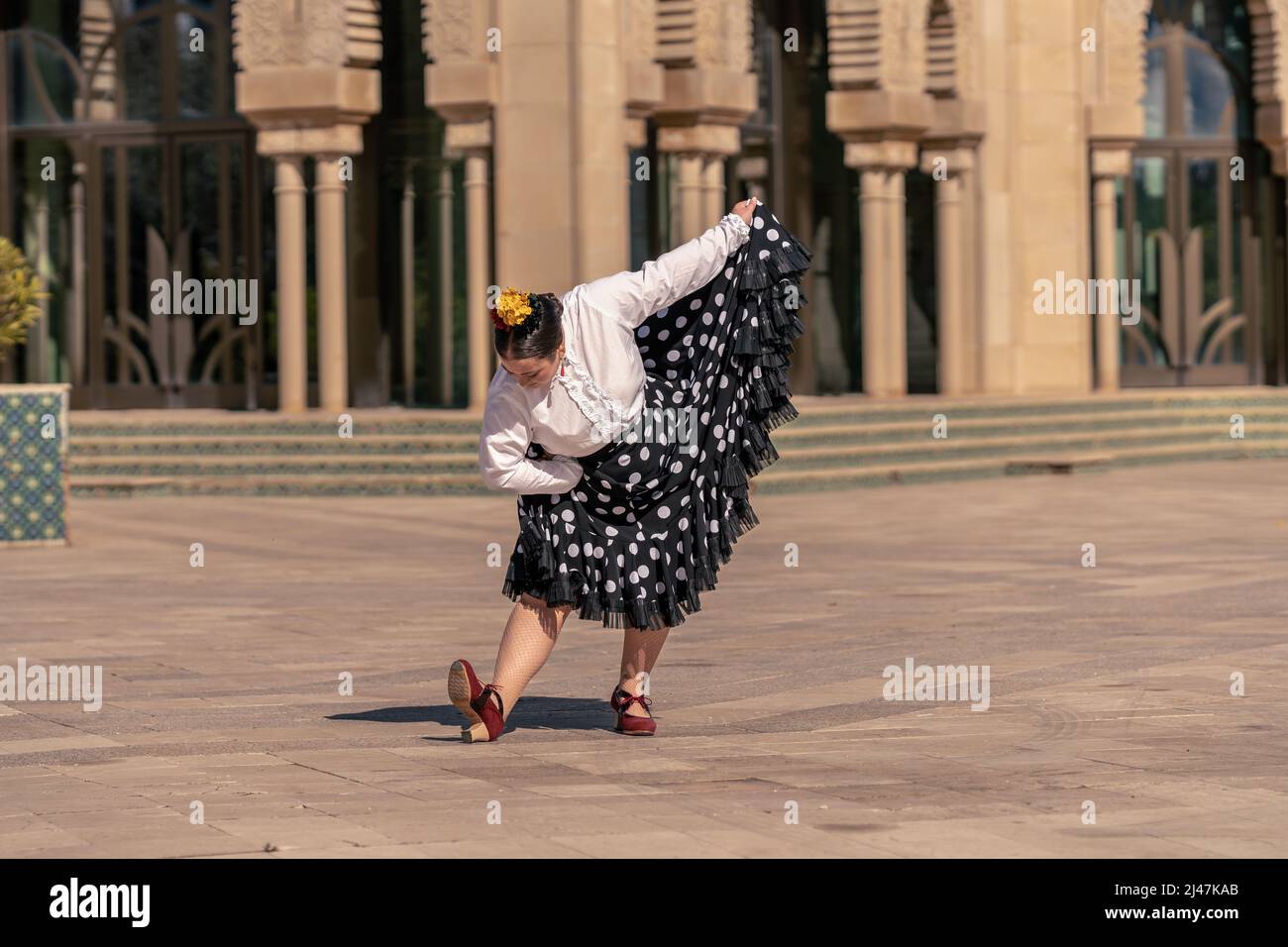 jeune femme habillée comme danseuse de flamenco se fauchant dans une place Banque D'Images