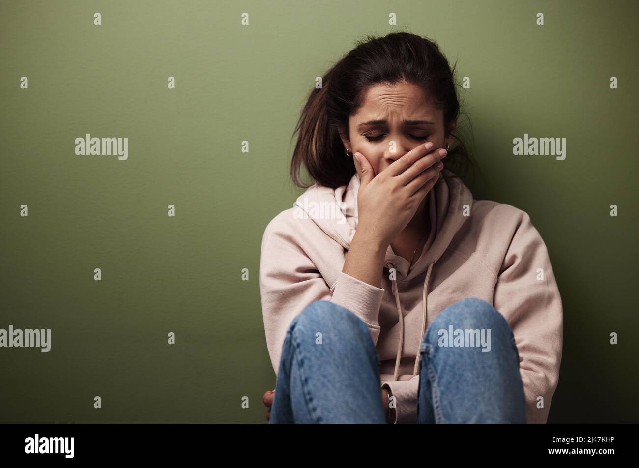 Il n'est pas sain d'être seul. Photo courte d'une jeune femme attrayante qui pleure sur fond vert. Banque D'Images