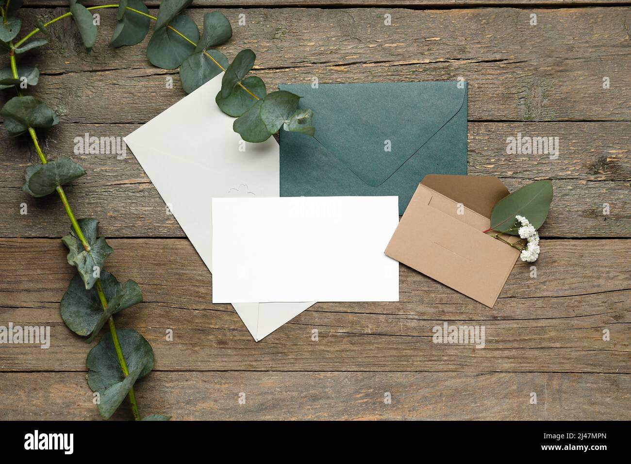 Enveloppes avec cartes vierges et branches d'eucalyptus sur fond de bois  foncé Photo Stock - Alamy