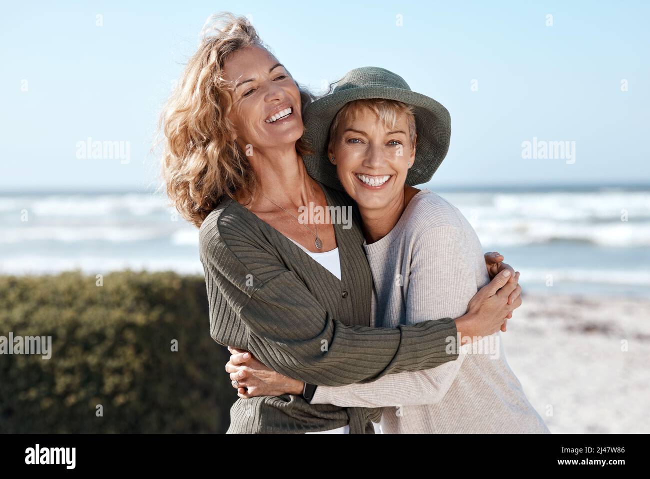 Meilleurs amis pour la vie. Coupe courte de deux belles femmes matures qui s'embrasent sur la plage. Banque D'Images