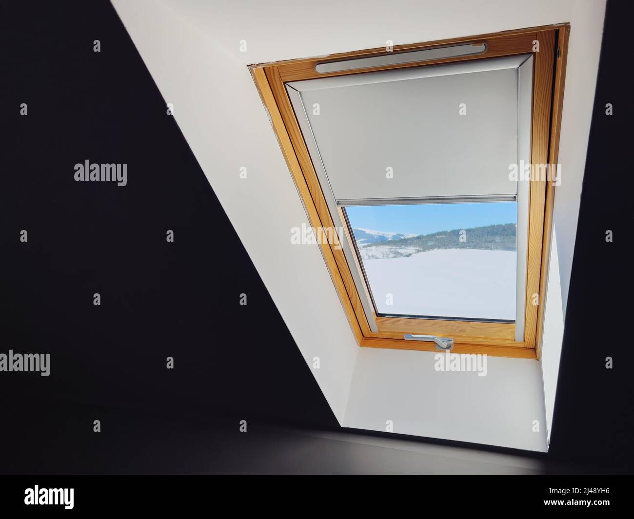 Fenêtre sur le toit en hiver vue de l'intérieur sombre de la pièce Banque D'Images