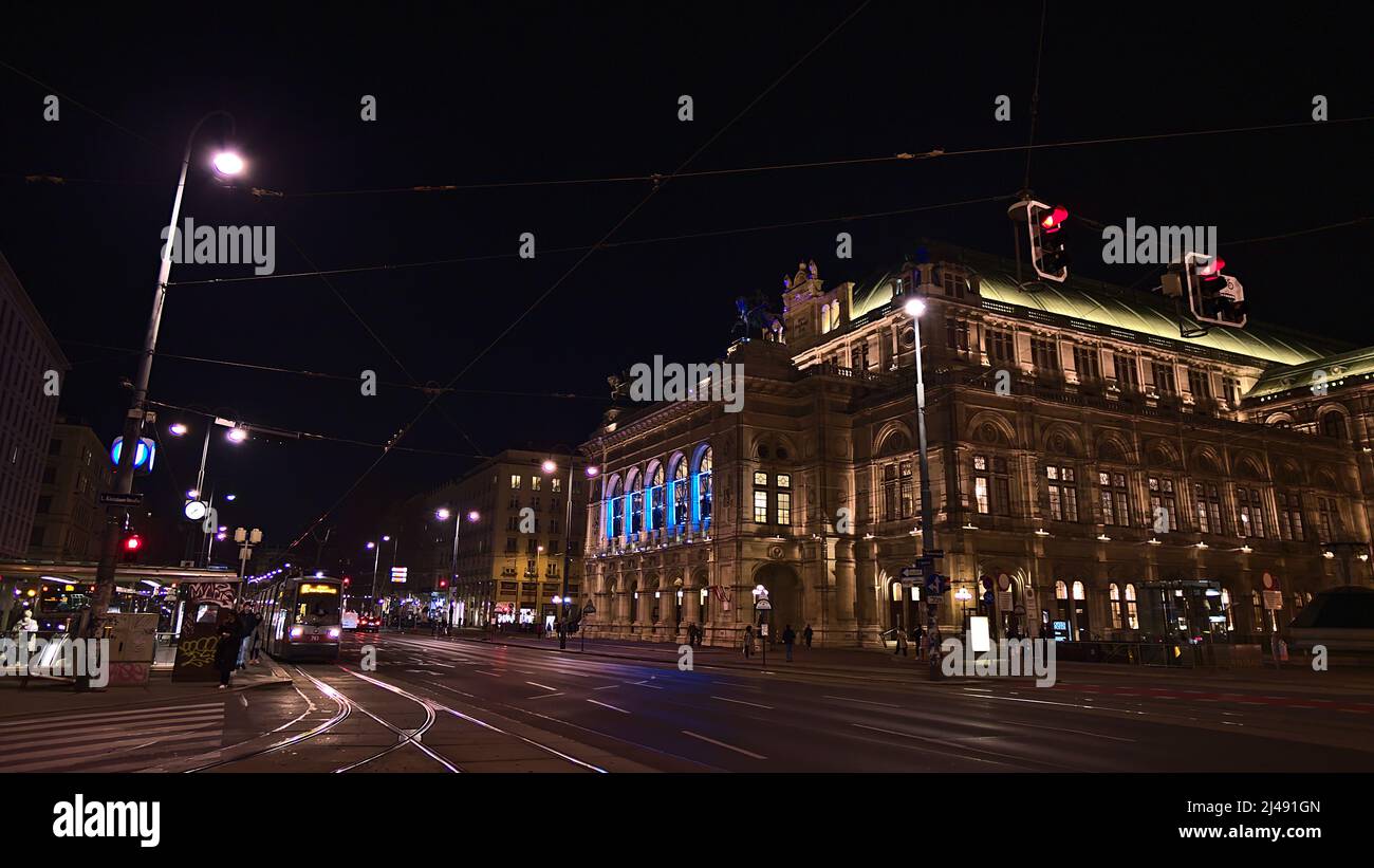 Belle vue de nuit sur la façade illuminée de l'Opéra national de Vienne en Autriche avec tram en face. Banque D'Images