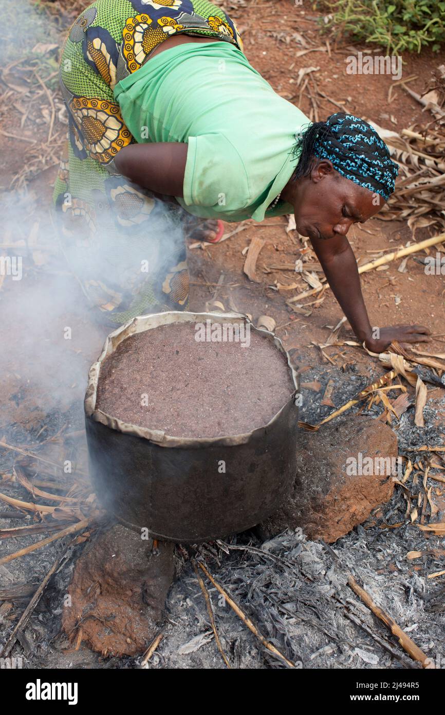 Stephanie Yinkamiye, mère de 6 enfants et de 11 petits-enfants, avec sa fille Maria Goreti, prépare de la bière de sorgho à vendre le lendemain. Stephanie a également adopté deux garçons orphelins du VIH. Secteur Mbazi, Huye disrict. Photo de Mike Goldwater Banque D'Images