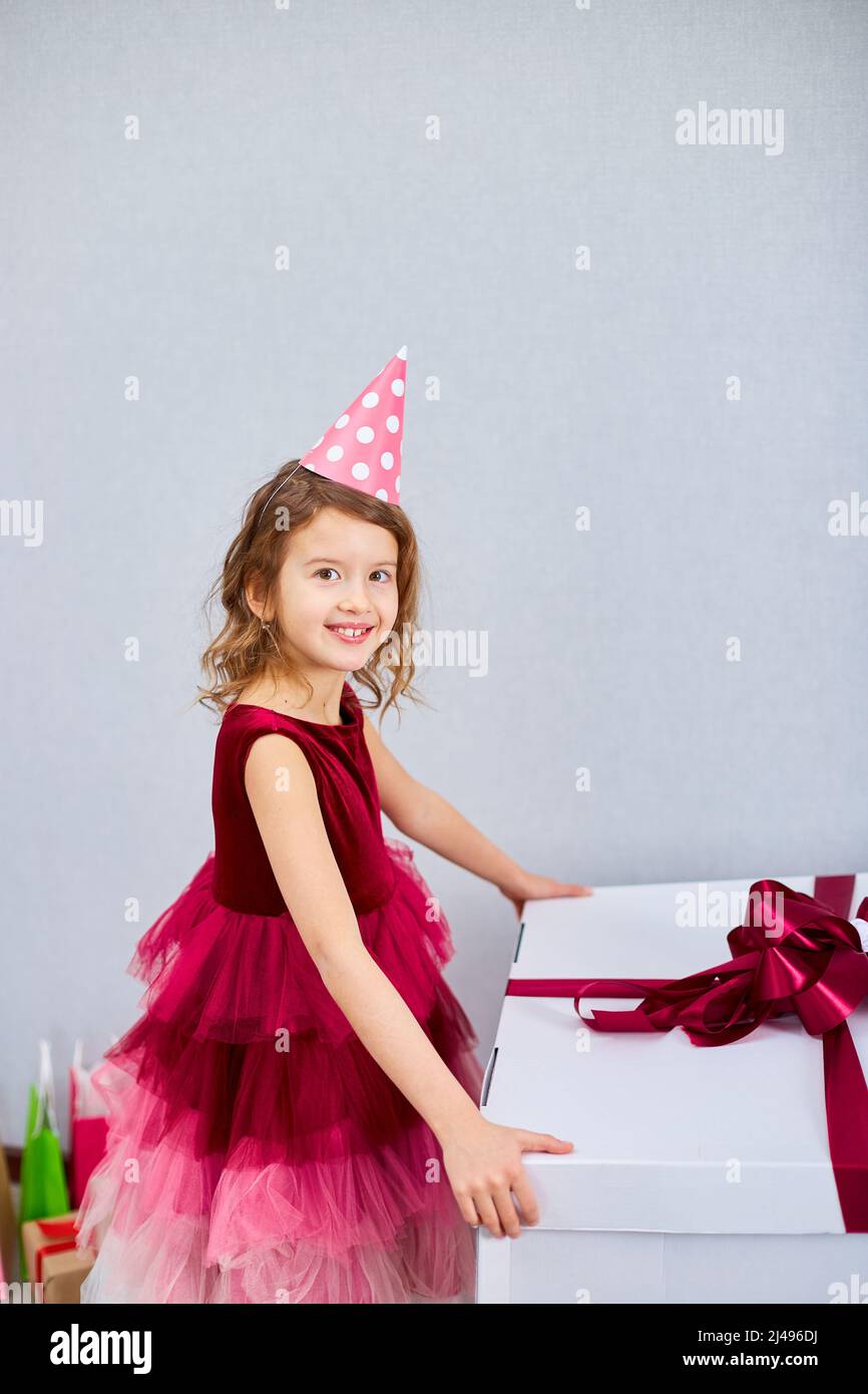 Joyeuse petite fille en robe rose et chapeau ouvert grand cadeau boîte  cadeau avec ballons à la maison fête streamers, Joyeux anniversaire.  Célébration Photo Stock - Alamy