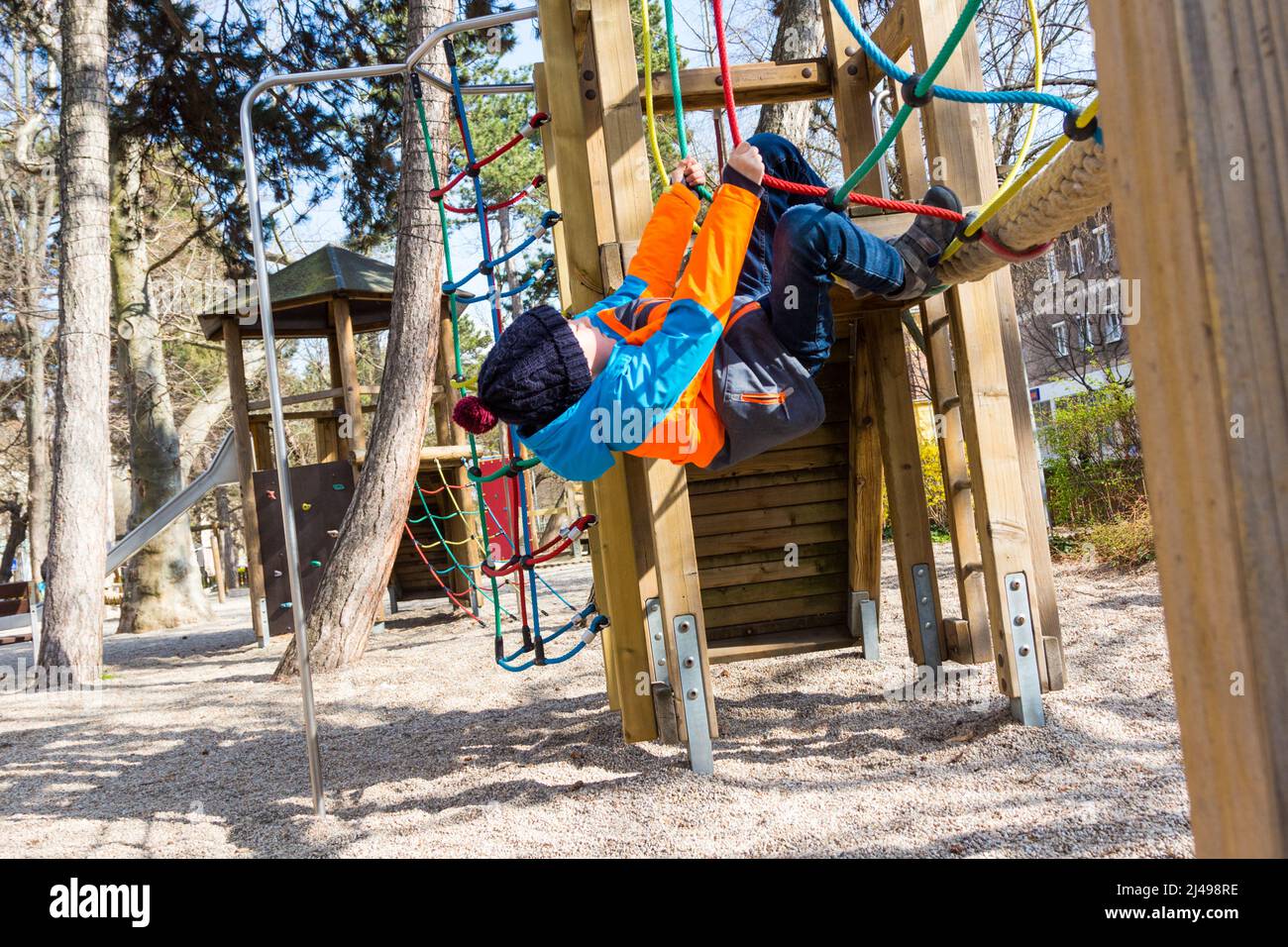 Enfant de 8 ans jouant sur le pont de corde à l'aire de jeux par temps frais au début du printemps, Sopron, Hongrie Banque D'Images