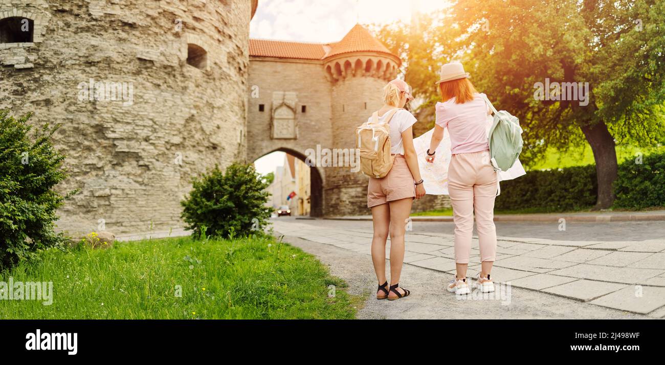 Deux femmes à la recherche de l'emplacement des sites touristiques sur la carte de la vieille Tallinn, Estonie. Banque D'Images