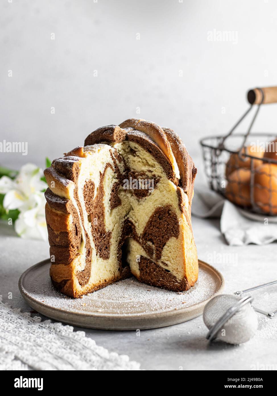 Gâteau de Pâques coupé kraffin arrosé de sucre en poudre. Gros plan sur un gâteau fait maison en deux couleurs. Cruffin. Orientation Vertica Banque D'Images