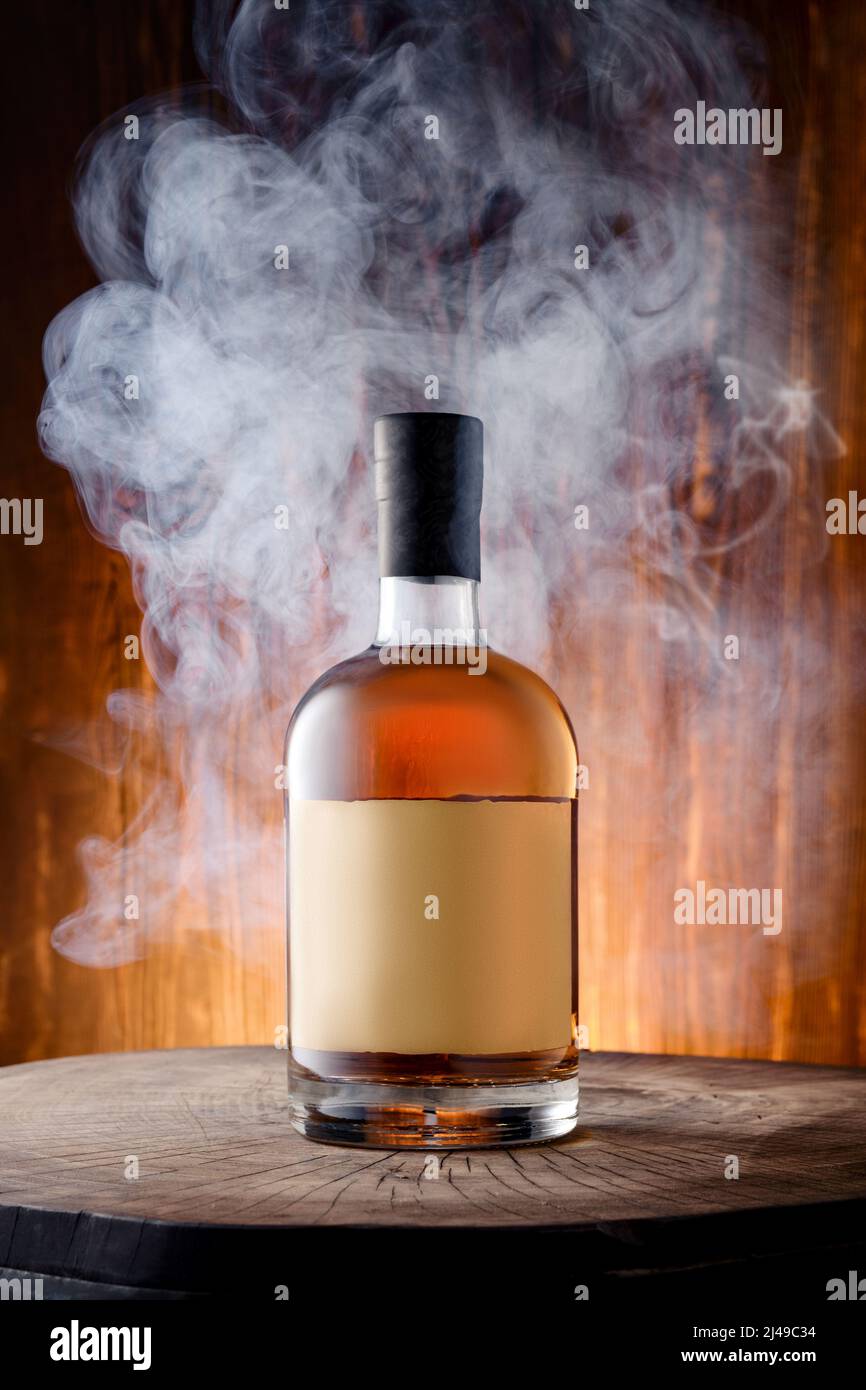 Bouteille de whisky de scotch fumé au malt mélangé entourée de fumée Banque D'Images