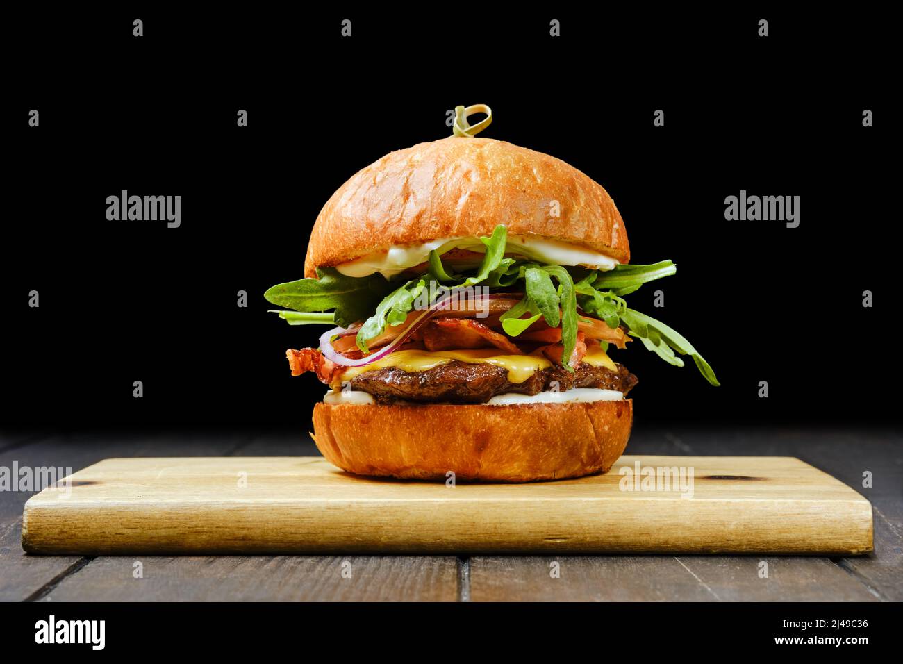 Savoureux hamburger au bœuf avec bacon sur une table de service en bois Banque D'Images