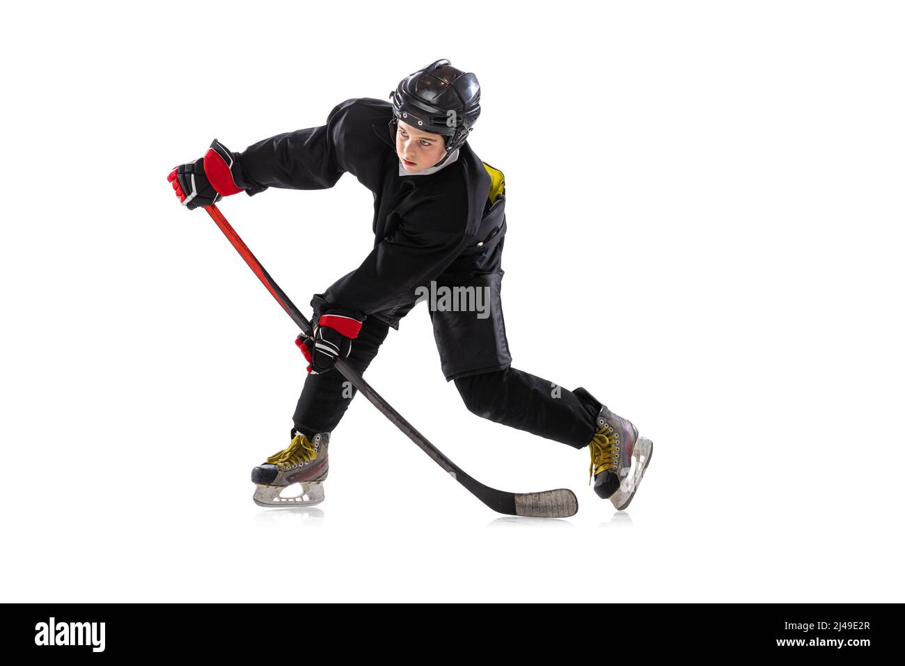 Sur la course. Enfant, joueur de hockey avec bâton sur cour de glace et fond blanc. Banque D'Images