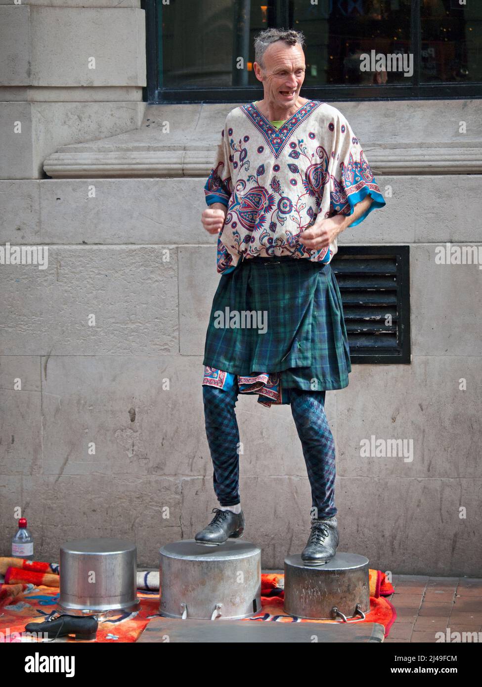 Un artiste de rue tape des danses sur des pots dans une rue Brighton Banque D'Images