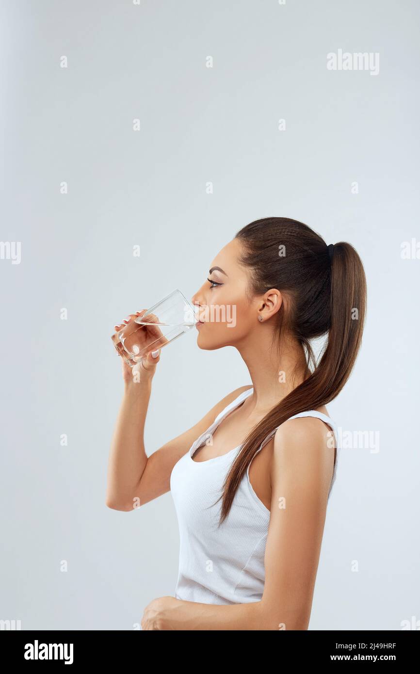 Belle femme tenant un verre d'eau. Buvez de l'eau. Concepteur de régime tenant le verre d'eau. Buvez de l'eau. Fille avec un verre d'eau. Concept de régime Banque D'Images