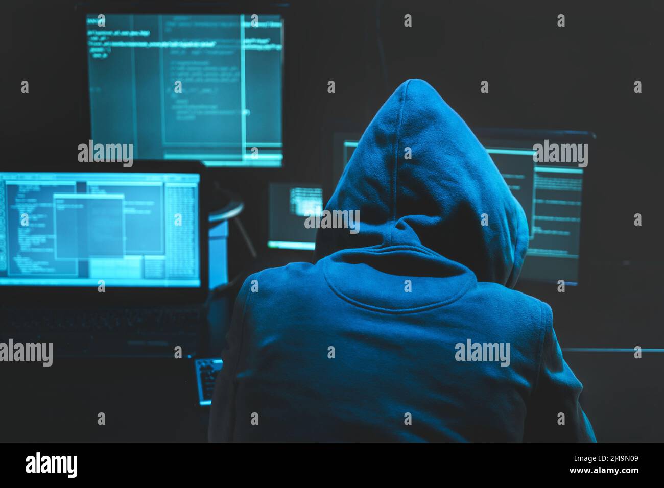 Hacker utilisant l'ordinateur pour organiser une attaque massive de violation de données sur les serveurs de gouvernement. Hacker dans la pièce sombre entouré d'ordinateurs Banque D'Images