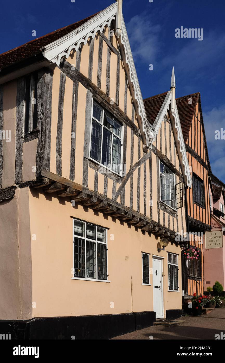 Les maisons à pans de bois dans la High Street à Lavenham, Suffolk, Angleterre, Royaume-Uni, comprennent (à gauche) no 6, construite en 1400s ou 1500s avec des gables jumeaux, et (à droite) 7-9, la Maison Crooked, construite vers 1395 dans le cadre d'une maison de hall médiévale, probablement pour un riche marchand de laine. Son pignon de devant penche de façon spectaculaire à gauche et aurait inspiré la vieille comptine rhyme de départ: «Il y avait un homme crooked, il a marché un mile crooked ...". Banque D'Images