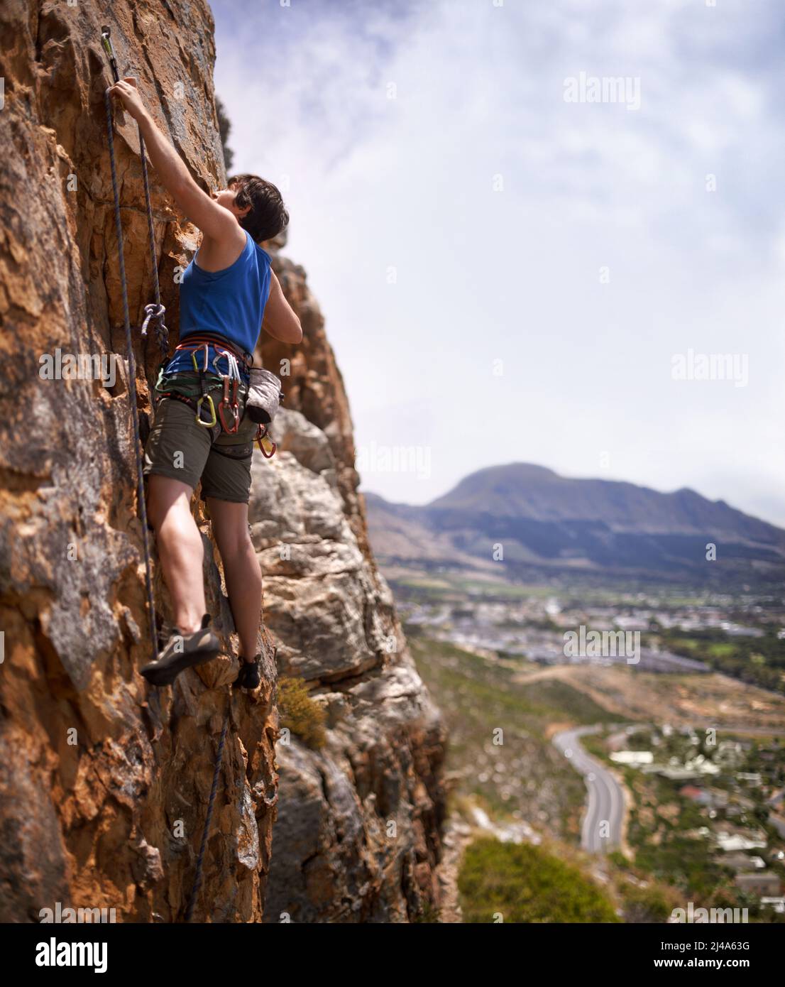 Grimpeur en chef courageux. Photo d'une jeune femme qui clippage dans un boulon pendant l'escalade. Banque D'Images