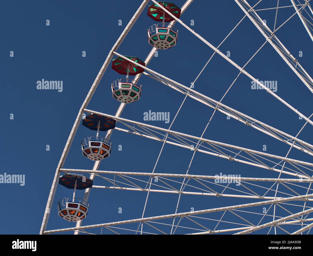 Vue rapprochée sur le sommet d'une grande grande roue de Ferris dans le parc d'attractions Wurstelprater à Vienne, Autriche avec cadre blanc et gondoles colorées le jour ensoleillé. Banque D'Images