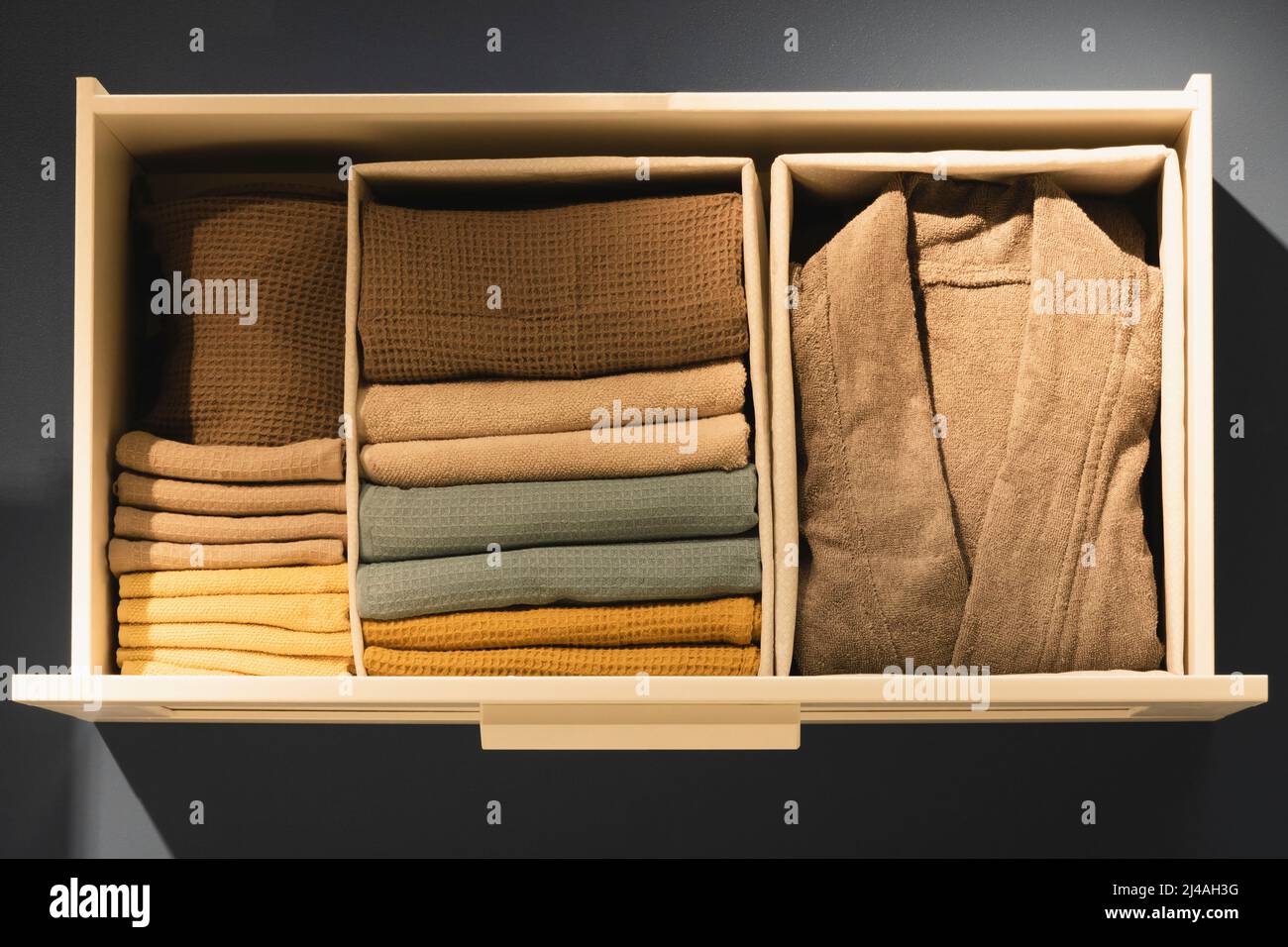 Ouvrez le tiroir avec les vêtements. Rangement vertical des vêtements, rangement, nettoyage des pièces. Vue de dessus Banque D'Images